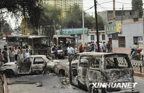 7月6日,乌鲁木齐市北湾街上停放着多辆被烧毁汽车。